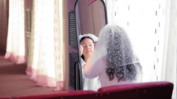 Una novia judía frente a un espejo se maquilla antes de la ceremonia de chuppah en el espejo. — Vídeos de Stock