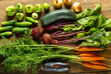 Tahta masadaki bitkilerle taze sebzeler toplayın.