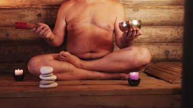 Kaplıcada bir adam şarkı söyleyen bir kaseyle meditasyon yapıyor..