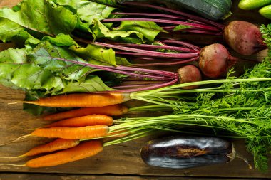 Tahta masadaki bitkilerle taze sebzeler toplayın.