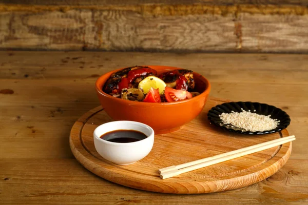 Soba, tavuklu ve sebzeli. Yuvarlak bir tabakta, soya sosu ve susam tohumlarıyla..