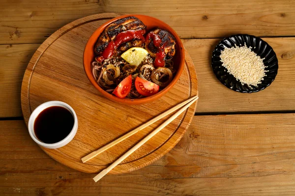 Soba with chicken and vegetables with soy sauce and sesame seeds near the sticks. — Stock Photo, Image