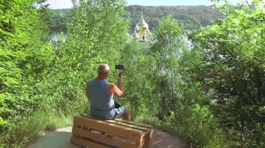 Seyahat hakkında cep telefonu olan bir erkek blogcu arkadan tapınaktan bahsediyor..