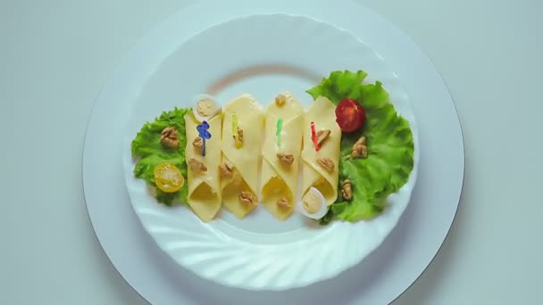 Rollen met kaas op een wit bord met kruiden en kwarteleitjes — Stockvideo
