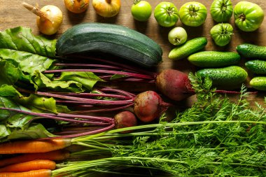 Tahta masadaki bitkilerle taze sebzeler toplayın.