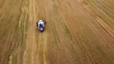 Bir biçerdöver tarlada olgunlaşmış tahıl toplar..