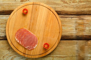 Tahtada dilimlenmiş jambon ve masada kiraz..