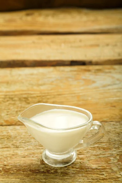 Cream in a jug on a wooden table. — Stock Photo, Image