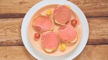 Jambonlu ve vişneli sandviçler bir tabakta daireler çizer..