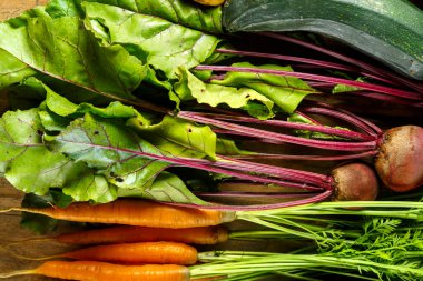 Tahta bir masada, çiftlikten toplanmış taze sebzelerle taze sebzeler toplayın..