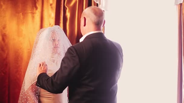 Der muslimische Bräutigam nähert sich der muslimischen Braut, lüftet den Schleier aus ihrem Gesicht und nimmt sie mit — Stockvideo