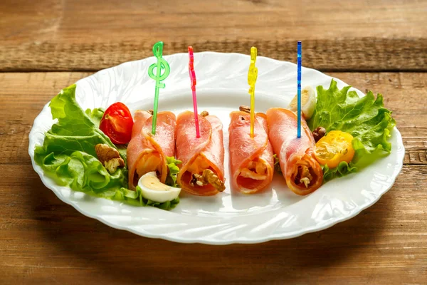 Ham rolls on a plate with cherry salad on a wooden table. save a place. — Stock Photo, Image