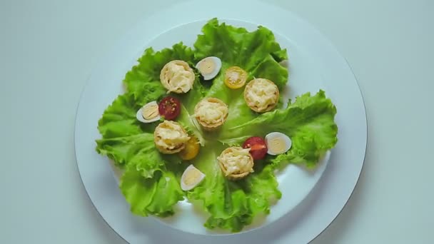 Tartaletas con queso y ajo en un plato blanco con hierbas y huevos de codorniz — Vídeos de Stock