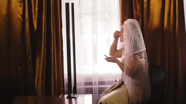 En judisk brud förbereder sig för bröllopet framför en spegel och sminkar sig — Stockvideo