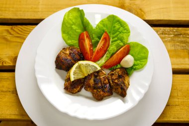 Domates, salata ve limonlu ızgara et parçaları..