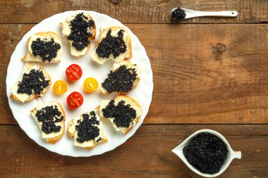 Havyarlı havyarlı havyarın yanındaki beyaz tabakta siyah havyarlı sandviç..