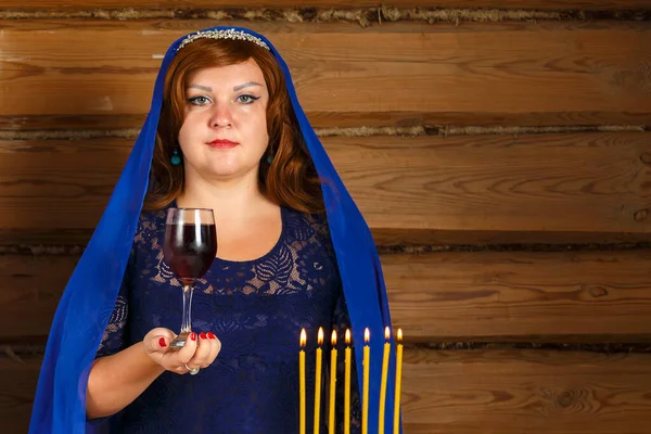 Am Vorabend von Rosch Ashan steht eine Jüdin neben brennenden Kerzen mit einem Glas Kiddusch-Wein in der Hand. — Stockfoto