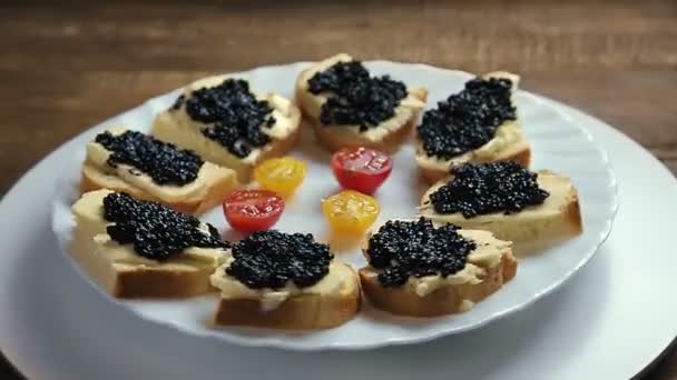 Sanduíches com caviar preto em uma placa branca giram em um círculo — Vídeo de Stock