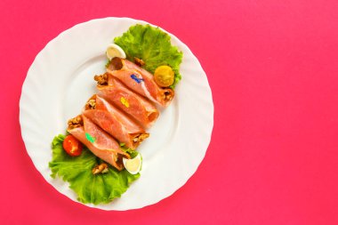 Tabakta jambonlu dürüm ve pembe arka planda yeşil salata. bir yer kaydet