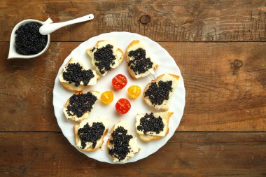 Havyarlı havyarlı havyarın yanındaki beyaz tabakta siyah havyarlı sandviç..