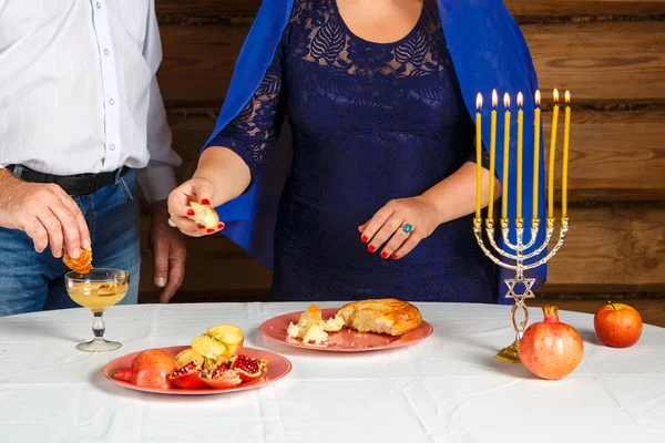 在Rosh Hashanah，一个无脸的犹太家庭、一个女人和一个男人在蜂蜜中蘸着切拉. — 图库照片