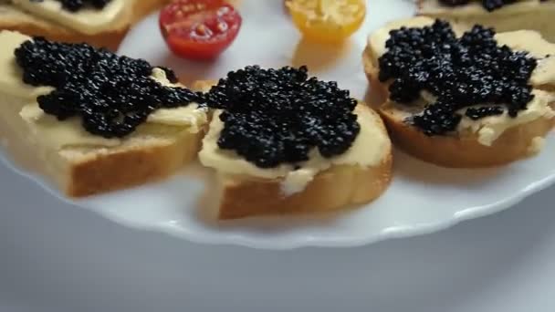 Smörgåsar med svart kaviar på en gammal träskiva roterar i en cirkel — Stockvideo