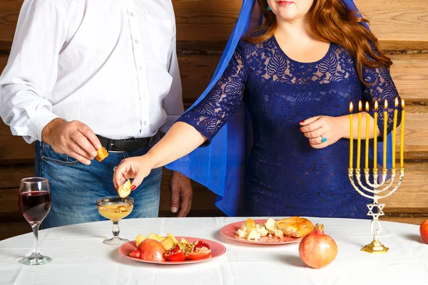 유대인 가족, 얼굴없는 남편과 아내로 가득 찬 로스 아슈나 축제 테이블에서 촛불을 켜고 꿀을 담갔다.. — 스톡 사진