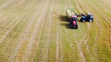 Hasat makineleri hasat makinası paketlenmiş samanları makineye yüklüyor.