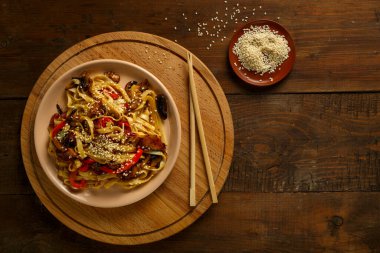 Tayland soslu tavuk ve mantarlı Udon. Yanında da susam tohumları var..
