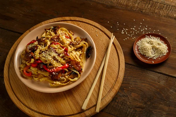 Tayland soslu tavuk ve mantarlı Udon. Yanında da susam tohumları var..