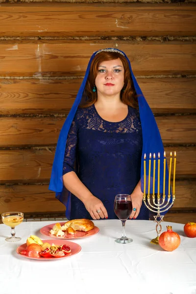 在Rosh Hashanah前夕 一位犹太妇女站在桌旁燃着蜡烛 垂直照片 — 图库照片