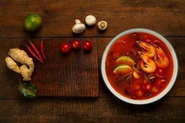 Tom zencefil, onluk ve mantarın yanında hafif bir tabakta karides ve limonlu tatlı patates çorbası. Yatay fotoğraf