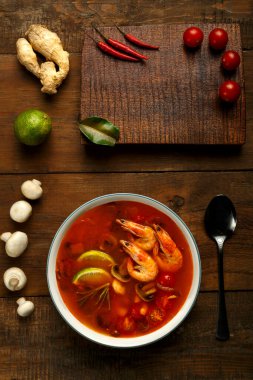 Tom zencefil, limon ve mantarlı hafif bir tabakta karides ve limonlu tatlı patates çorbası. Dikey fotoğraf