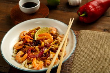 Udon 'u sebzelerle, mantarlarla ve karideslerle yakın çekim yap. Yatay fotoğraf