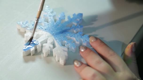 Weibliche Hände basteln mit blauen Aquarell-Schneeflocken Dekorationen für die Weihnachtsmalerei. — Stockvideo