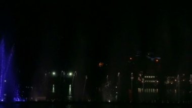 Gece gökyüzünün arka planında çok renkli fıskiyeler var.