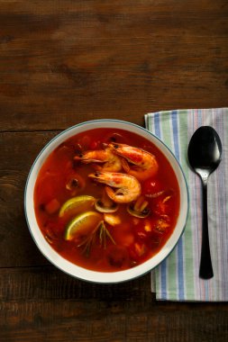 Tom yer elması çorbası, karides ve limonlu hafif tabakta, peçetenin yanında..