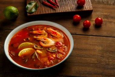 Limon, biber ve kirazlı hafif bir kasede karides ve limonlu Tom tatlı patates çorbası..