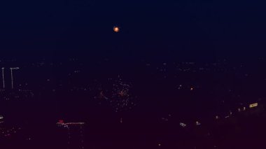 Gece gökyüzündeki havai fişekler şehrin arka planına karşıdır.