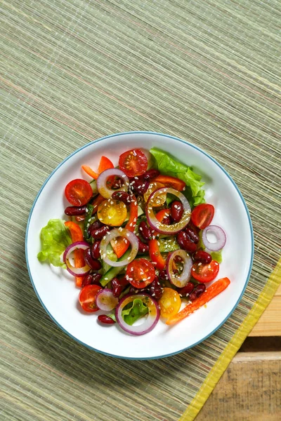 Hafif tabakta susam tohumlu Asya salatası bambu masa örtüsü ve ahşap masa örtüsü..