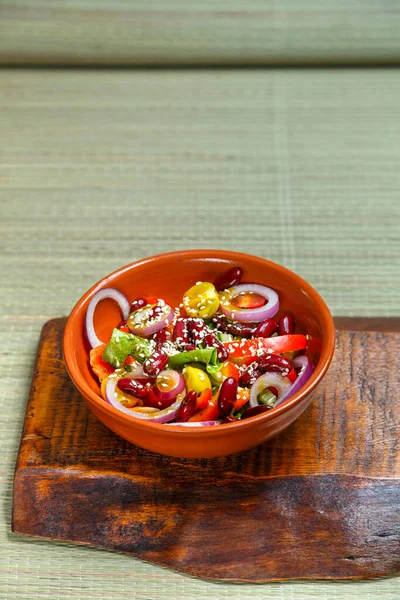 A plate of pan-Asian salad with sesame seeds and tamarind on wooden stands.