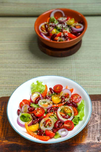 Twee borden Pan-Aziatische salade met sesamzaad op houten statieven. — Stockfoto