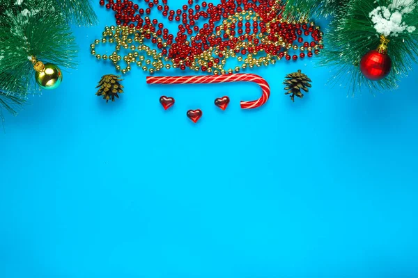 Fond de Noël de branche de pin bleu dans une rangée de cônes perles et bonbons. — Photo