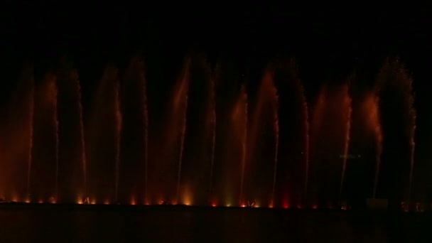 Glinsteren met verschillende kleuren fonteinen op een watershow 's nachts — Stockvideo