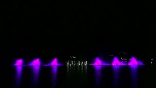 Разноцветные фонтаны на воде на фоне ночного неба с различными комбинациями. — стоковое видео