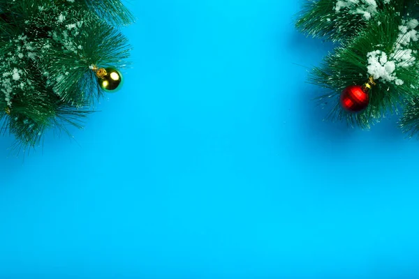 Kerst achtergrond blauw takje sosea bedekt met sneeuw en decoratie bal. — Stockfoto
