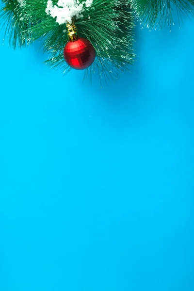 Jul bakgrund blå tall gren i snön på det med en boll dekoration . — Stockfoto