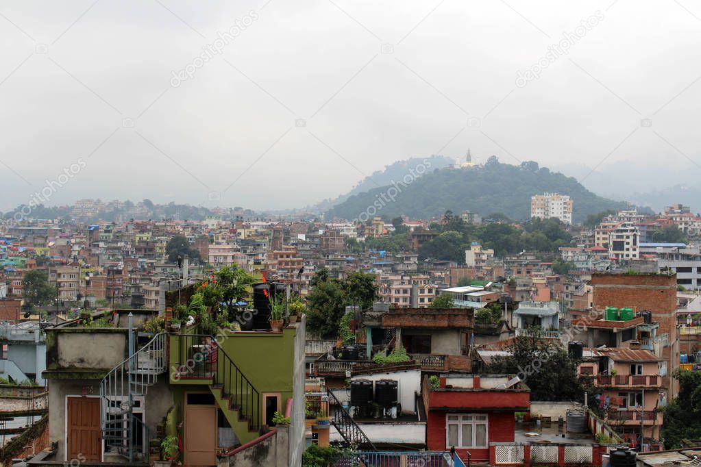 The view of Swayambhunath Stupa from the rooftop in Kathmandu during cloudy day. Taken in Nepal, August 2018.