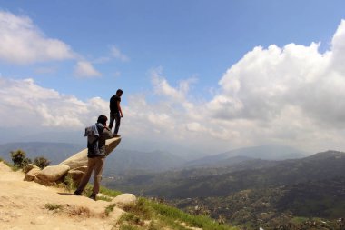 İyi Nepalce arkadaş bir taş üzerinde fotoğraf çekmek için yardımcı oluyor. Dhulikhel, Nepal, Ağustos 2018 alınan.
