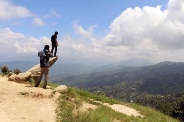 İyi Nepalce arkadaş bir taş üzerinde fotoğraf çekmek için yardımcı oluyor. Dhulikhel, Nepal, Ağustos 2018 alınan.
